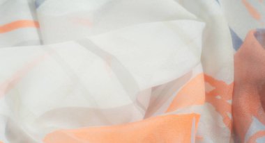 Beyaz arka planda parlak turuncu ve yumuşak mavi desenli soyut kumaş bulanıklığı. Akan kıvrımlar ve havadar doku derinlik ve hafiflik hissi yaratır..