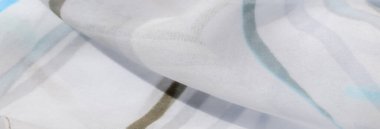 Katmanlı kareli desenli Bulanık Yeşil kumaş dokunmuş yapısını vurguluyor ve kumaşların üzerindeki ışık ve gölge karışımından derinlik ekliyor.