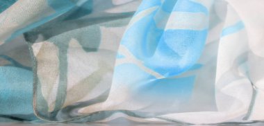 Pürüzsüz, akışkan desenleri ve narin kıvrımları olan beyaz ve mavi kumaştan bir bulanıklık. Yumuşak renk karışımı, sakin ve havadar bir hafiflik hissi yayar..