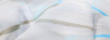 Pürüzsüz, akışkan desenleri ve narin kıvrımları olan beyaz ve mavi kumaştan bir bulanıklık. Yumuşak renk karışımı, sakin ve havadar bir hafiflik hissi yayar..