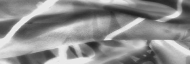 Çapraz ışık çizgileri ile bulanık şeffaf kumaş çarpıcı bir kompozisyon oluşturur. Gri tonlu palet ve gölgeli alanlar derinlik ve görsel olarak dinamik bir doku sunar.