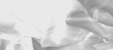 Üst üste binen çizgilerin bulanıklığı ve kumaş üzerindeki gölgeler dinamik bir gri tonlama yaratıyor. Yumuşak dokular, açık ve koyu tonlar arasındaki karşıtlığı artırır