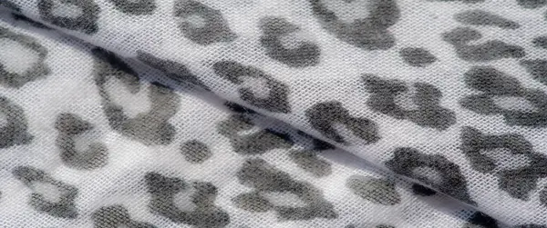 Hayvan izi motifli beyaz ve gri desenli bir kumaşın bulanık görüntüsü. Yumuşak kıvrımlar ve detaylı dokuma zarif, modern bir stil hissi veriyor..