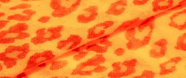Turuncu ve sarı leopar benzeri lekeli bulanık kumaş, hem egzotik hem de zarif bir tasarım sunuyor, cesur moda ve iç dekorasyon için mükemmel bir tekstil oluşturuyor..