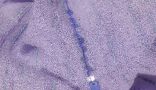 Yeşil ve mavi işlemeli bulanık lavanta tekstil ve pullar. Nazik perdeler ve ışıldayan pullar zarif, lüks bir kumaş dokusu yaratır..