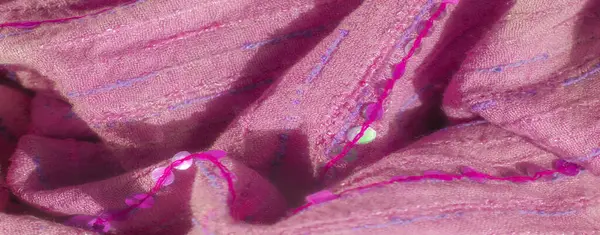 Pembe, desenli kumaş, ince çizgiler ve mor ve mavi tonlarda pullu süslemeler, canlı bir kontrast yaratıyor. Yumuşak katlar estetik çekiciliğini arttırır.