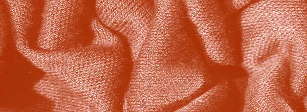 Görüntü, turuncu kumaşın yumuşak, dalgalı kıvrımlı görüntüsü. Karmaşık dokusu derinlik ekler, kumaşın hassas ve yumuşak kalitesine vurgu yapar..