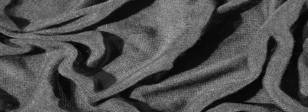 Karmaşık kıvrımlı, koyu, zengin bir kumaşın bulanık görüntüsü, katmanlı ve dokulu bir etki yaratıyor. Monokrom tonları, kumaşın sunu, dokunmuş dokusunu, derinliğini ve zarafetini vurguluyor.
