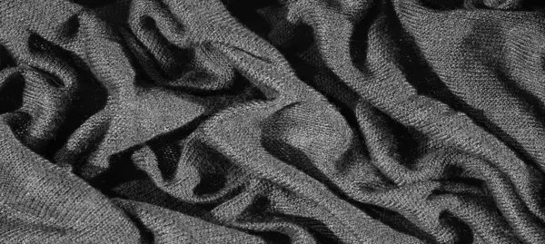 Karmaşık kıvrımlı, koyu, zengin bir kumaşın bulanık görüntüsü, katmanlı ve dokulu bir etki yaratıyor. Monokrom tonları, kumaşın sunu, dokunmuş dokusunu, derinliğini ve zarafetini vurguluyor.