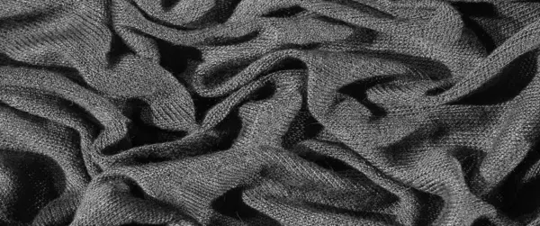 Karmaşık kıvrımlı, koyu, zengin bir kumaşın bulanık görüntüsü, katmanlı ve dokulu bir etki yaratıyor. Monokrom tonları, kumaşın sunu, dokunmuş dokusunu, derinliğini ve zarafetini vurguluyor.