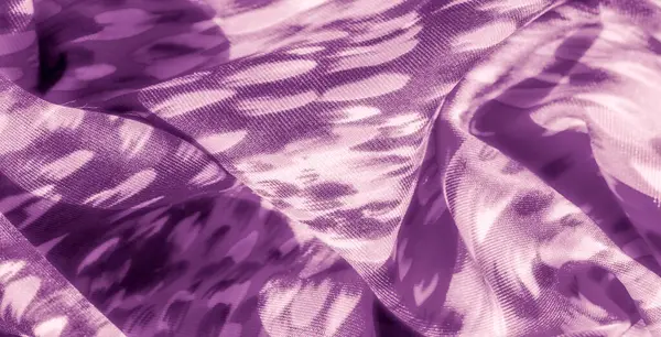 Mor kumaşın üzerindeki bulanık ışık ve gölge yumuşak dokular ve akış çizgileriyle soyut bir etki yaratıyor. Kumaşın hareketi, sanatsal cazibesini artırmak için güzel bir şekilde yakalıyor..