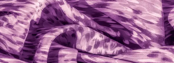 Kıvrımlı, mor renkli, kıvrımlı bir kumaşın bulanıklığı. Katlar yumuşak gölgeler ve röfle oluşturarak kompozisyona derinlik ve akıcılık hissi katıyor..