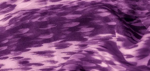 Kıvrımlı, mor renkli, kıvrımlı bir kumaşın bulanıklığı. Katlar yumuşak gölgeler ve röfle oluşturarak kompozisyona derinlik ve akıcılık hissi katıyor..