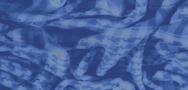 Hassas desenleri ve dokuması olan bulanık mavi tekstil. Kumaş, soyut bir görsel etki yaratan karmaşık, akışkan tasarımlarla yumuşak ve havadar görünüyor..