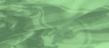 Houndstooth desenli yeşil kumaş bulanıklığı. Malzemenin ince kıvrımları var, derinlik ve hareket yaratıyor, hassas gölgeler ve röfle oyunlarıyla..