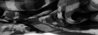 Görüntü. Katmanlı damalı yeşil kumaş, dokuma yapısını vurguluyor ve kumaşların üzerindeki ışık ve gölge karışımından derinlik ekliyor..