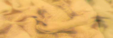 Görüntü. Katmanlı damalı yeşil kumaş, dokuma yapısını vurguluyor ve kumaşların üzerindeki ışık ve gölge karışımından derinlik ekliyor..