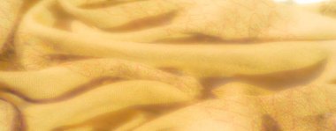 Görüntü. Katmanlı damalı yeşil kumaş, dokuma yapısını vurguluyor ve kumaşların üzerindeki ışık ve gölge karışımından derinlik ekliyor..