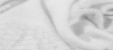 Görüntü. Katmanlı damalı yeşil kumaş, dokuma yapısını vurguluyor ve kumaşların üzerindeki ışık ve gölge karışımından derinlik ekliyor..