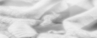 Görüntü. Katmanlı damalı yeşil kumaş, dokuma yapısını vurguluyor ve kumaşların üzerindeki ışık ve gölge karışımından derinlik ekliyor..