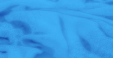 Derin ve yumuşak bir görsel cazibe yaratan karmaşık kıvrımları olan akışkan, dokulu mavi bir kumaşın bulanıklığı. Kumaş dokusu pürüzsüz mavi renklere boyut ekler.