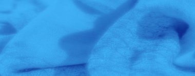 Mavi kumaş bulanıklığı, yumuşak ve akıcı bir dokuyu gösteriyor. Kumaşın kıvrımları ve yumuşak maddesi rahatlatıcı, rüya gibi bir atmosfer yaratarak arka plan tasarımları veya sanatsal projeler için ideal hale getiriyor..
