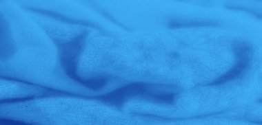 Yumuşak kıvrımları ve ince dokuları olan pürüzsüz, akan mavi kumaş üzerinde bulanık bir etki. Kumaş zarif ve zarif görünüyor, ince gölgeler onun katmanlı görünümünü güçlendiriyor.