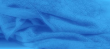 Yumuşak kıvrımları ve ince dokuları olan pürüzsüz, akan mavi kumaş üzerinde bulanık bir etki. Kumaş zarif ve zarif görünüyor, ince gölgeler onun katmanlı görünümünü güçlendiriyor.
