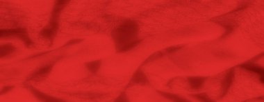 Görüntü, bu canlı kırmızı kumaş kıvrımları ve yumuşak dokusu ile moda, tasarım ve lüks temalar için sıcak ve cezbedici bir arka plan yaratıyor..