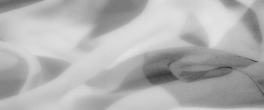 Bulanık beyaz kumaş zarifçe kıvrılarak yumuşak kıvrımlara dönüşüyor. Hafifliği ve basitliği somutlaştırıyor. Yumuşak dokusu karmaşıklık katıyor, lüks ve huzurlu görsel temalar için ideal..