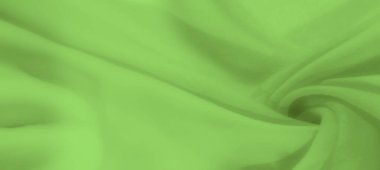 Yumuşak kıvrımlı, pürüzsüz, açık yeşil kumaştan oluşan bulanık bir görüntü. Kumaşın ince dokusu görüntüye derinlik ve akıcı bir estetik katar.