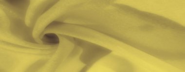 Yumuşak kıvrımlı sarı kumaş bulanıklığı ve yumuşak bir doku, sıcak ve rahatlatıcı bir his veriyor. Kumaşlar ince kıvrımlar derinlik ve zarafet getirir, güzel bir tekstil arkaplanı yaratır.