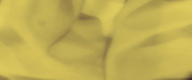 Yumuşak, sarı kumaş kıvrımları üzerindeki bulanık etki zarif, akıcı bir doku yaratır, yumuşak dalgaları yakalar ve rüya gibi, soyut bir düzende pürüzsüz kıvrımlar..