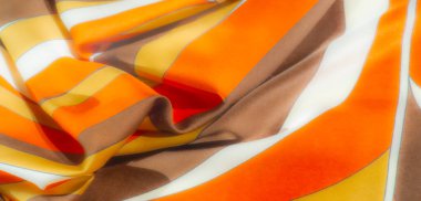 Bulanık - Beyaz aksanlı kahverengi, sarı ve turuncu renkli bir kumaş, kıvrımlı bir desen ile dizilmiş, ipeksi ve ince, akıcı dokular, zarafet katıyor.