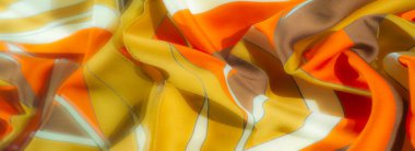 Işıl ışıl turuncu, sarı ve kahverengi tonlu çizgili kumaş, yumuşak kıvrımlı ve akışkan bir tasarım, tekstil için parlak ve sıcak bir görsel cazibe sağlıyor..