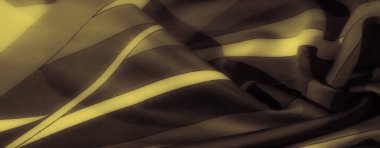 Zarif kıvrımları ve dokuları olan bulanık siyah ve sarı çizgili kumaş. Canlı kontrastlar ve pürüzsüz kumaş yüzeyi görsel bir bağlantı oluşturur..