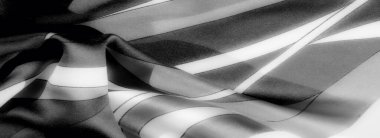 Bulanık, karmaşık kıvrımlar ve pürüzsüz doku bu gri pullu kumaşı tanımlar, zıt ışık ve karanlık desenler maddeye derinlik ve zarafet ekler..