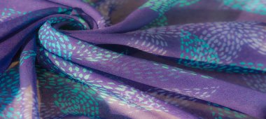 Yumuşak turkuaz aksanlı mor kumaş büyüleyici, akışkan bir şekil oluşturur. Bu soyut, havadar tekstil her ortama sakinleştirici ama zarif bir dokunuş getiriyor..