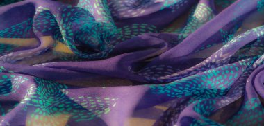 Renk ve dokuların karışımı bunu sanatsal ve moda projeleri için ideal bir seçim haline getirmektedir ve turkuaz desenli canlı bir mor kumaş ışığı güzel bir şekilde yakalar.