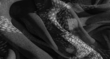 Bulanık, yumuşak, akışkan kıvrımlı ve ince desenli zarif gri tonlu kumaş. Işık ve gölge derinlik getirir, klasik, zamansız cazibesini arttırır..