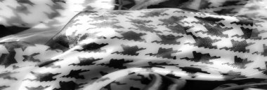 Görüntü. Siyah-beyaz saten kumaş. Karmaşık zincir desenleri ve çiçek desenleri var. Parlak, dokulu yüzey sofistike ve sanatsal bir görünüm yaratır.