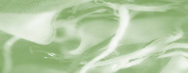 Birbirine dolanmış iplikleri ve kıvrımları olan bulanık yeşil kumaş, desenli ve katmanlı bir etki yaratır, soyut arka planlar veya sanatsal kavramlar için idealdir..