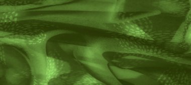 Karmaşık desenli yeşil kumaşın bulanık görüntüsü katmanlı, dokulu bir yüzey oluşturuyor. Yumuşak kıvrımlar soyut, doğadan esinlenilmiş tasarıma derinlik ve boyut ekler.