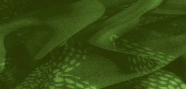 Karmaşık tasarımları olan yumuşak yeşil kumaş bulanıklığı. Nazikçe katlayıp yansıtan ışık. İnce desenler katmanların arasından çıkar, hem yumuşak hem de görsel olarak büyüleyici ruhani bir kalite sunar..