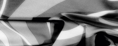 Görüntü, siyah ve beyaz çizgili kumaş zarif bir şekilde bükülmüş, çarpıcı ve sofistike bir tekstil kompozisyonu yaratan bir ışık ve gölge karışımı sergiliyor..