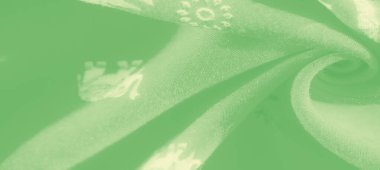 Karmaşık beyaz çiçek desenli yeşil kumaş, narin ve rahatlatıcı bir doku oluşturmak için yumuşakça örtülmüş. Yumuşak kıvrımlar ve hafif görünüm zarafet ve zarafet ekler.,