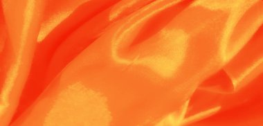 Hassas kıvrımlara sarılı ipek turuncu kumaş bulanıklığı, ince renklerle altın bir parıltı yayıyor. Doku pürüzsüz, lüks bir görünüm veriyor..