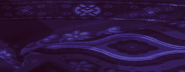 Bulanık, koyu mor kumaş. Karmaşık çiçekli ve geometrik desenli, ince parıltılarla süslenmiş. Doku derinlik ve sofistike bir son ekler..