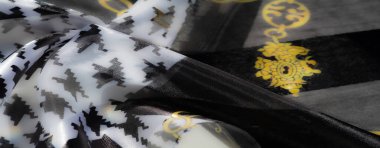 Karmaşık, siyah beyaz kumaş ve pırıl pırıl altın zincirlerle süslenmiş. Zarif tasarım, sofistike ve sanatsal çekicilik yayar..