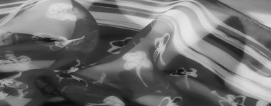 Gri tonda bulanık kumaş tasarımı, yumuşak çiçek aksanlı. Akan kumaşın üzerindeki ışık etkileşimi şeffaf ve zarif dokusunu vurgular..